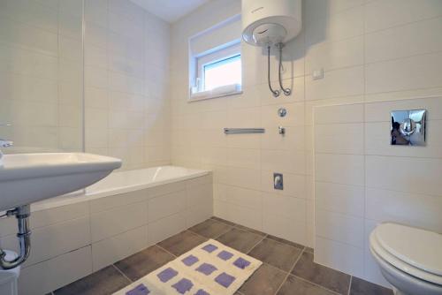 a white bathroom with a sink and a toilet at Apartments Bilanovic in Tisno