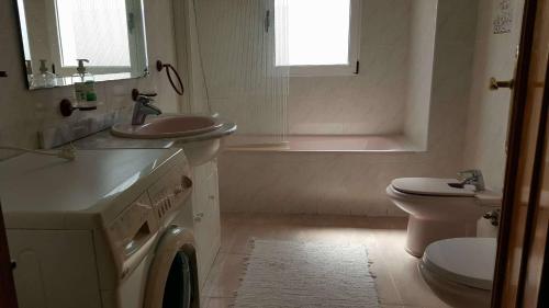 a white bathroom with a sink and a toilet at Casa de los amigos in Busot