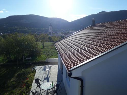 a patio with two chairs and a table on a roof at Little Mostar house in Mostar