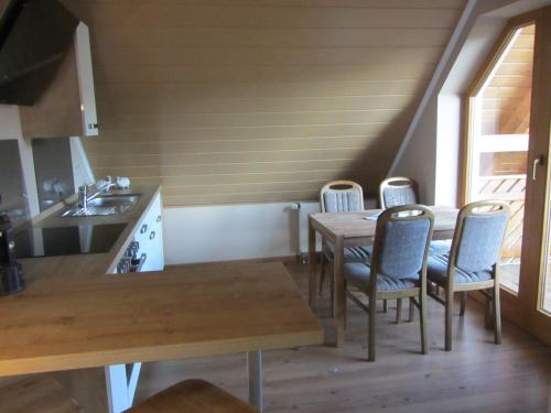 kuchnia i jadalnia ze stołem i krzesłami w obiekcie Fewo No. 17- Langgons / Oberkleen w mieście Langgöns