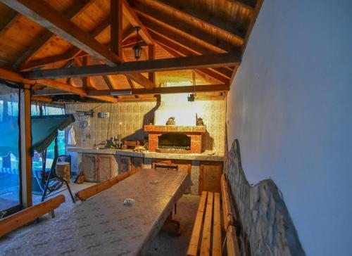 um quarto amplo com uma mesa e uma lareira em Guest House Gorski Kut em Granitovo