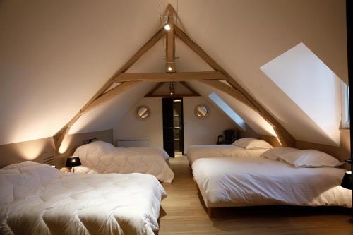 a room with three beds in a attic at Gîte de la Crayère in Gionges