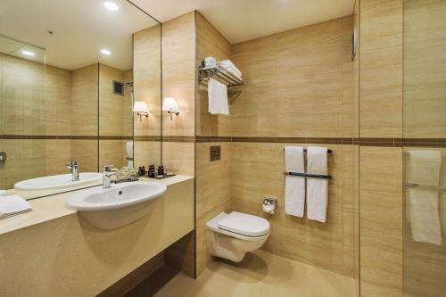 uma casa de banho com um WC, um lavatório e um chuveiro em SkyCity Hotel Auckland em Auckland