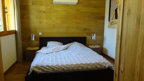 a bedroom with a bed with two nightstands and two lamps at Chalet Les Jumelles in Les Allues