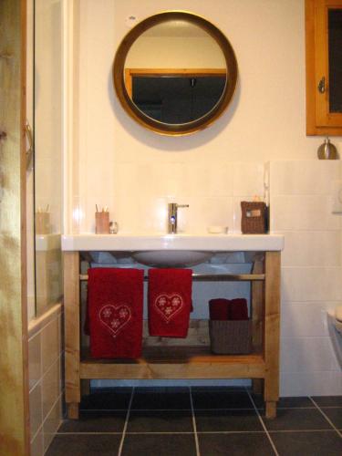 Les AlluesにあるChalet Les Jumellesのバスルーム(赤いタオル2枚、鏡付)