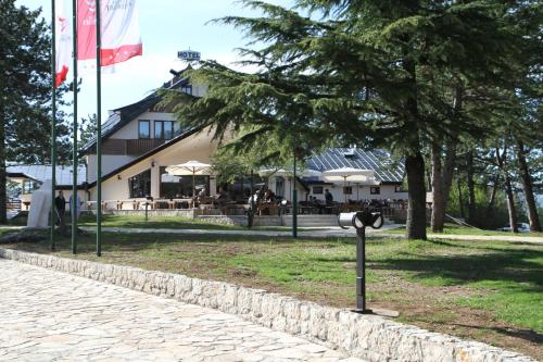 a parking meter in the grass next to a building at Hotel Trebjesa in Nikšić