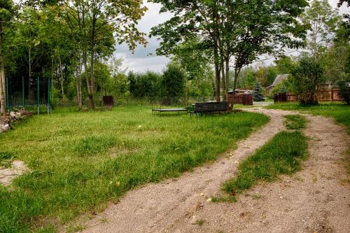 a dirt road leading to a park with a bench at Aleksandrówka - Domek Anastazja in Trześcianka