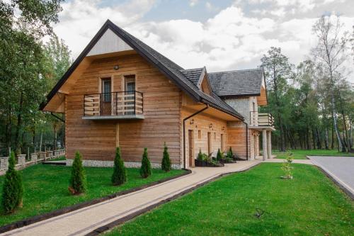 a wooden house with a gambrel roof at Zajazd Gołębiowski in Lipsko