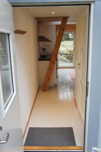 a tiny house with a staircase in a kitchen at Idöborgs Stuguthyrning in Nämdö