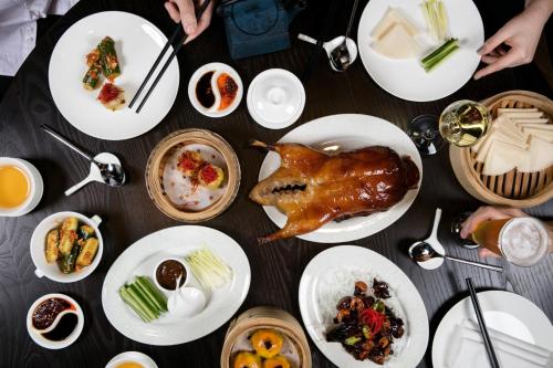 a table with plates of food and a chicken on it at SkyCity Hotel Auckland in Auckland