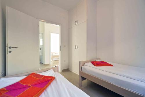 a bedroom with two beds and a mirror at Apartments Bilanovic in Tisno