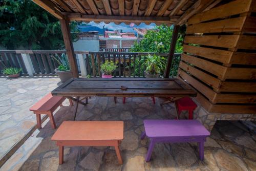 a wooden picnic table and benches in a gazebo at Rossco Hostel & Hotel in San Cristóbal de Las Casas