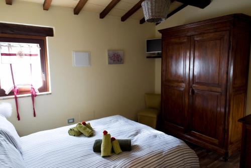 ein Schlafzimmer mit einem Bett mit zwei ausgestopften Tieren darauf in der Unterkunft Casa la Quiete in Torgiano