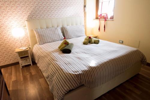 a bedroom with a bed with two stuffed animals on it at Casa la Quiete in Torgiano