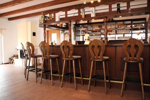 a row of wooden stools at a bar at Pension Landidylle in Wohlenhagen