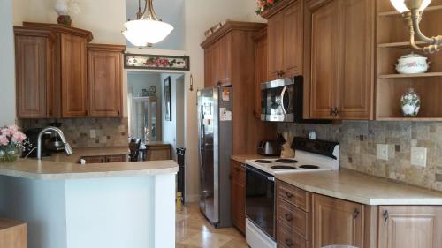 a kitchen with wooden cabinets and a stainless steel refrigerator at Modern Pool Home in Spring Hill