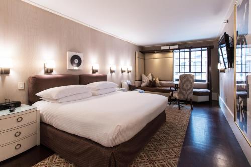 a bedroom with a large bed and a living room at City Club Hotel in New York