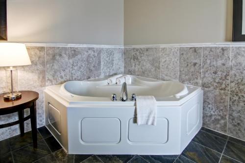 a bath tub with a sink in a bathroom at Best Western Plus Brandon Inn in Brandon