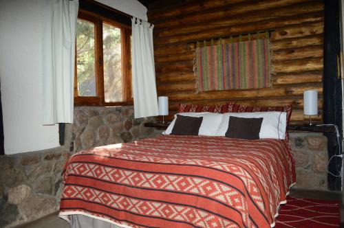Säng eller sängar i ett rum på Cabañas Rio Mendoza