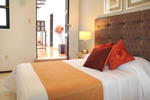 a bedroom with a large bed with red pillows on it at Hotel La Casa de María in Oaxaca City