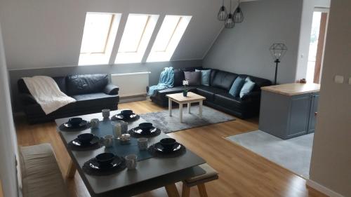 uma sala de estar com um sofá e uma mesa em Apart Hotel 37 (108 m2) em Polanica-Zdrój