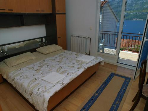 a bedroom with a bed and a large window at Apartments Adriatic in Korčula
