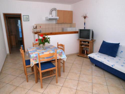 sala de estar con mesa, cama y TV en Apartments Adriatic en Korčula