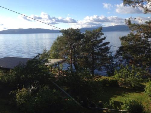 a view of a lake with trees and a house at Private House & Bungalow by the sea in Trondheim