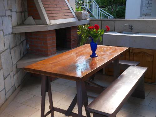 a wooden table with a vase with flowers on it at Apartments Adriatic in Korčula