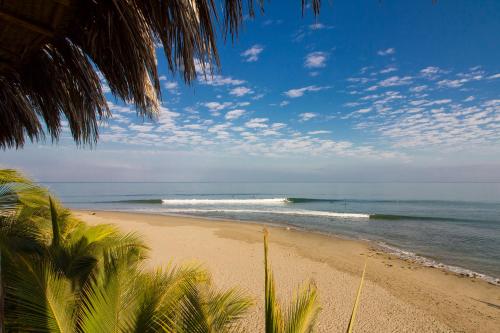 a view of a beach with palm trees and the ocean at Las Olas in Máncora