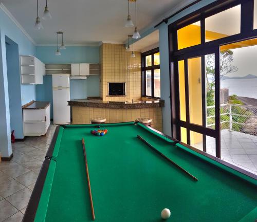 a kitchen with a pool table in a room at Pousada Pedra das Tartarugas in São Francisco do Sul