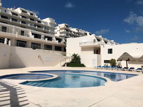 a swimming pool in front of a building at MARLIN TURQUESA DEPARTAMENTOs FRENTE AL MAR in Cancún