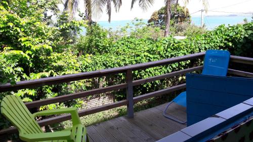two chairs sitting on a deck with the ocean in the background at Meryem in La Trinité