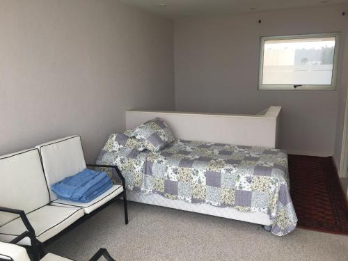 a bedroom with a bed and a couch and a window at Duplex Jacuzzi San Alfonso del Mar in Algarrobo