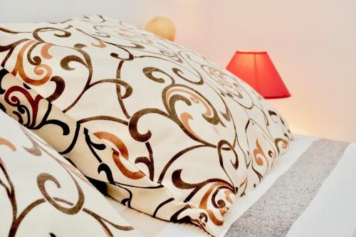 łóżko z brązowo-białym kocem i czerwoną lampą w obiekcie Rosette Apartment w mieście Seget Vranjica
