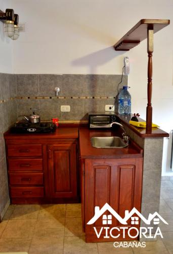 a kitchen with a sink and a counter top at Victoria Cabañas in Tigre