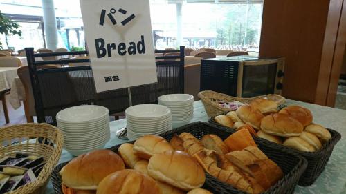 two baskets of bread sitting on a table with plates at Tateyama Prince Hotel in Omachi