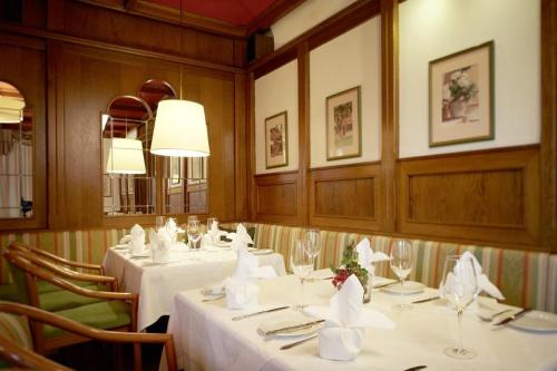 a dining room with white tables and chairs at Hotel Lindner in Vöcklabruck