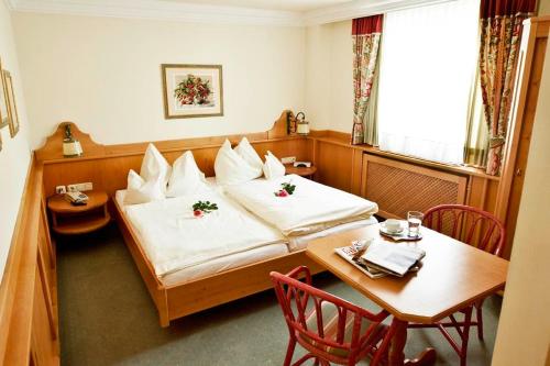 a hotel room with a bed and a table and chairs at Hotel Lindner in Vöcklabruck