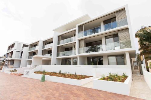 a large white building with plants in front of it at Bluewater Apartments in Kiama