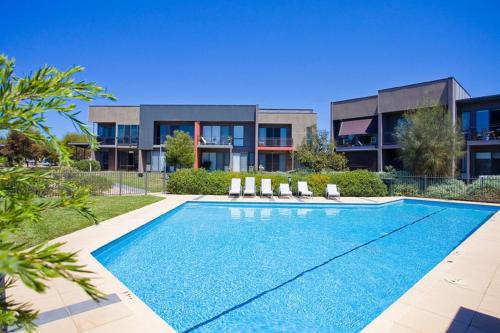 a swimming pool in front of a house at 3 Bedroom Townhouse - Pool and Tennis Court Access in Torquay