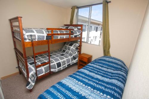 a bedroom with two bunk beds and a window at Departamento La Serena in La Serena