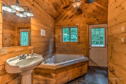 a bathroom with a tub and a sink at Magnolia Streamside Resort in Canadensis