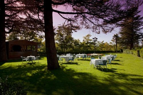 a group of tables and chairs in a field with a tree at Parador de Teruel in Teruel