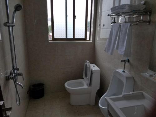 La salle de bains est pourvue de toilettes et d'un lavabo. dans l'établissement Wuyuan Man Shan Inn, à Wuyuan