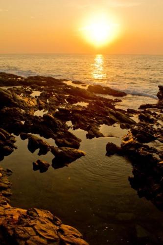 a sunset over the ocean with a reflection in the water at Villa Lucky Star in Tangalle