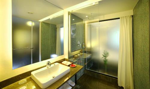 a bathroom with a sink and a shower and a mirror at The Royale Senate Race Course, Bangalore in Bangalore