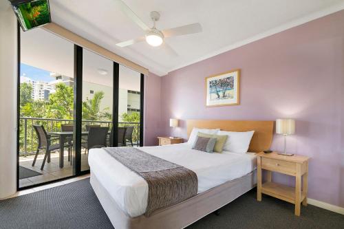 a bedroom with a large bed and a balcony at BreakFree Grand Pacific in Caloundra
