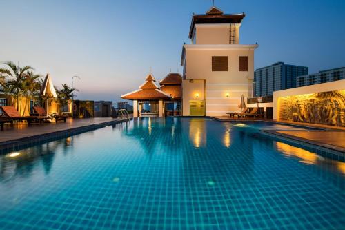 a swimming pool in front of a building with a clock tower at Aiyara Palace in Pattaya North