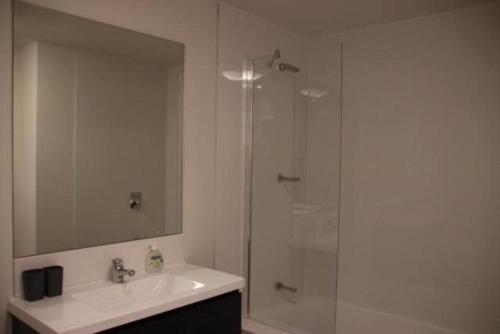 a bathroom with a sink and a shower with a mirror at Liverpool New Apt 2BR and 2Bath in Liverpool